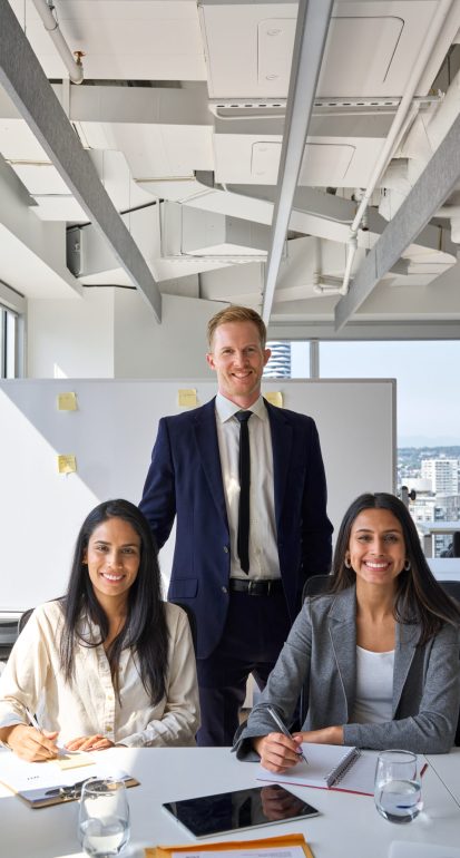 Happy professional diverse team business people in office meeting room. International company workers group, multiethnic smiling employees colleagues staff posing for team vertical portrait.