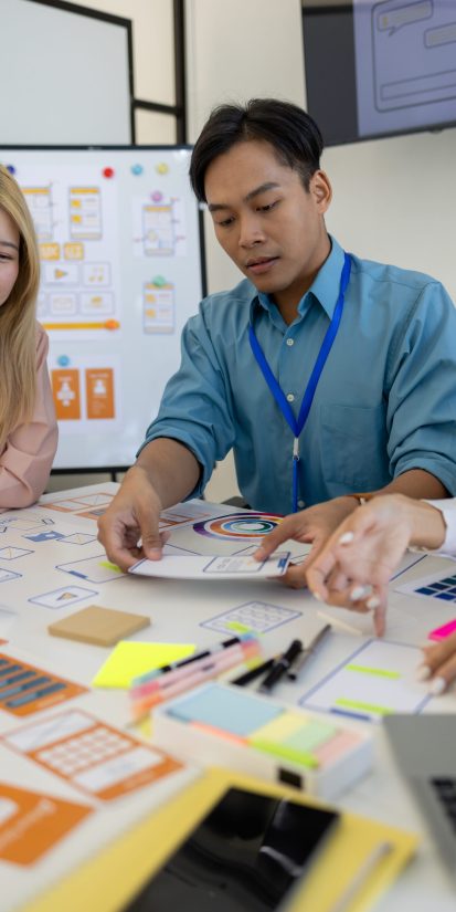 ux, ui, web and mobile app designers are discussing the look and feel of the website or app they are designing including color schemes and layouts to make it easy and enjoyable for users